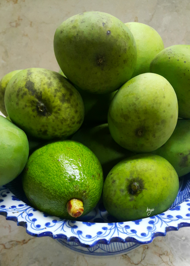 Green mangoes and an avocado